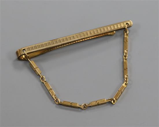 A 9ct. gold tie clip with chain.